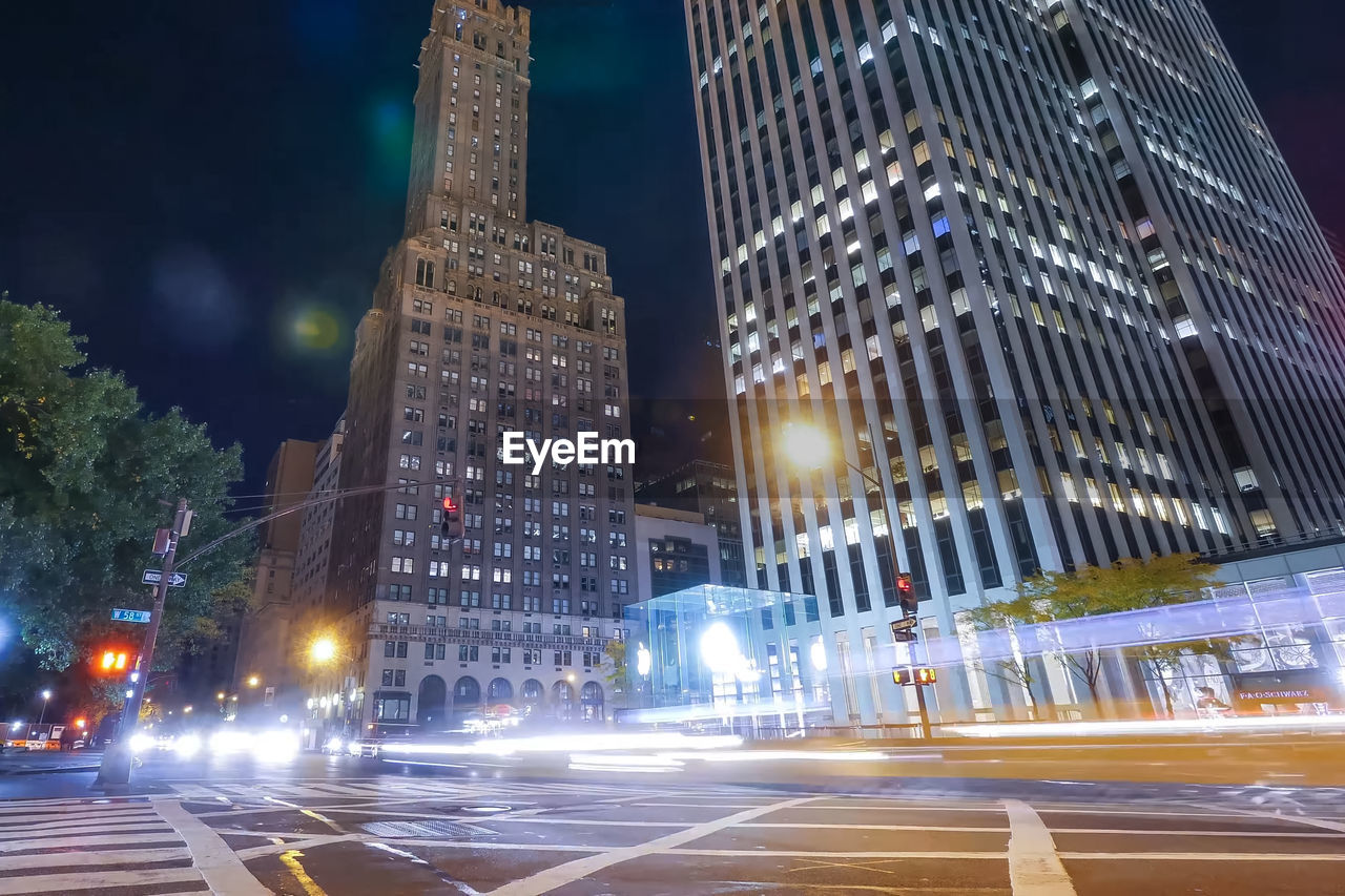 Illuminated city street and buildings at night