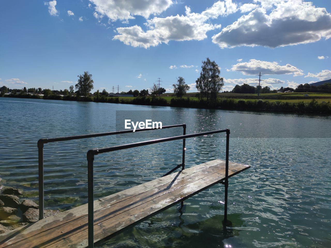 RAILING BY LAKE AGAINST SKY