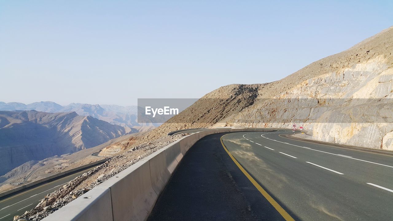 Road by mountain against clear sky