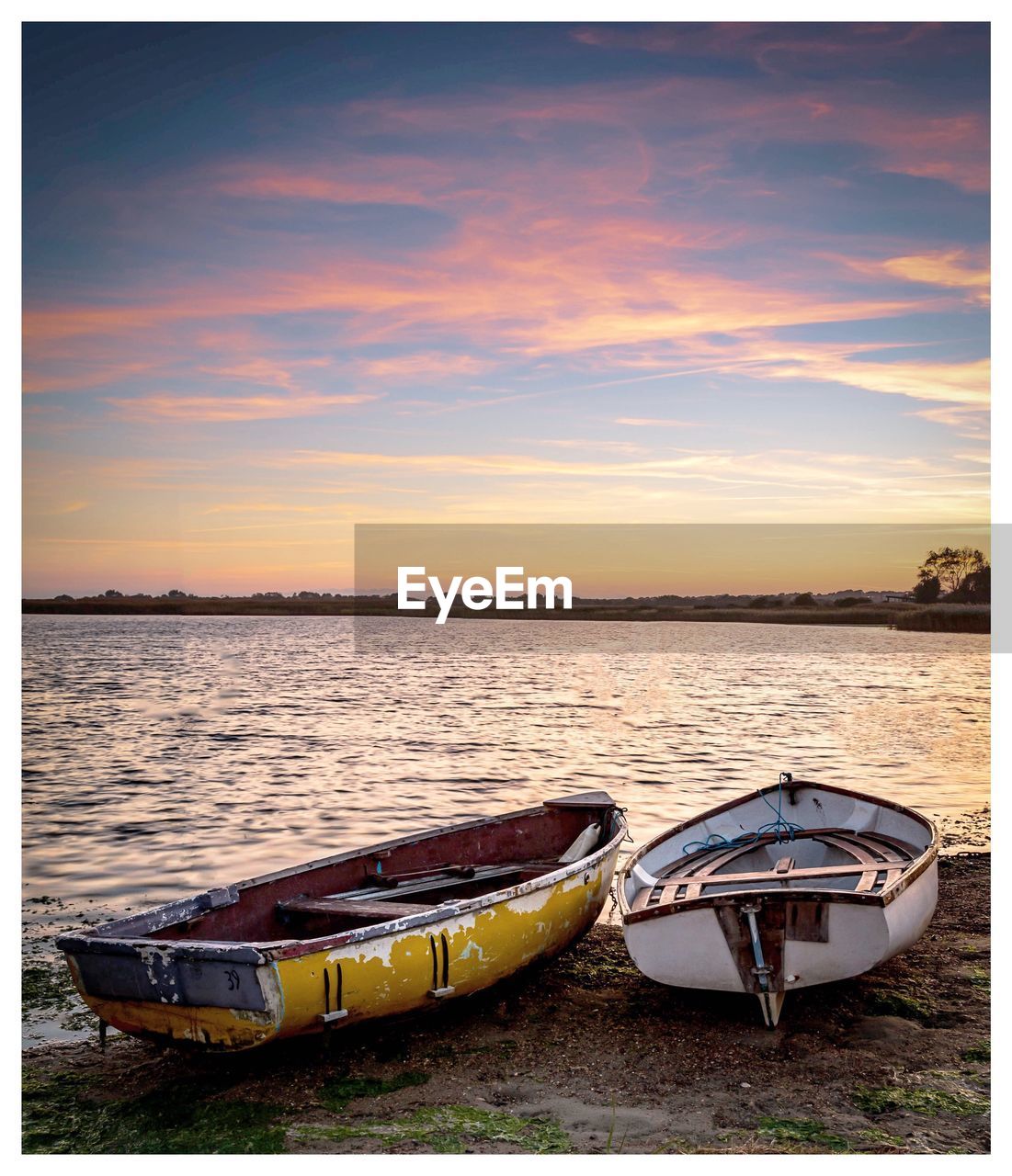 BOAT MOORED AT LAKE AGAINST SKY DURING SUNSET