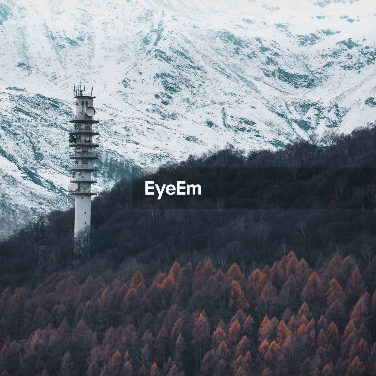 Tower against snow covered mountains