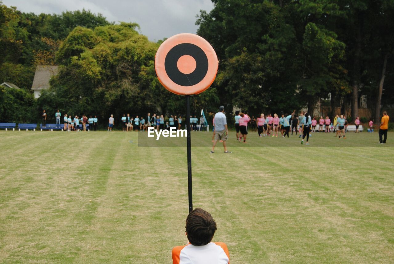 People at playing field by trees