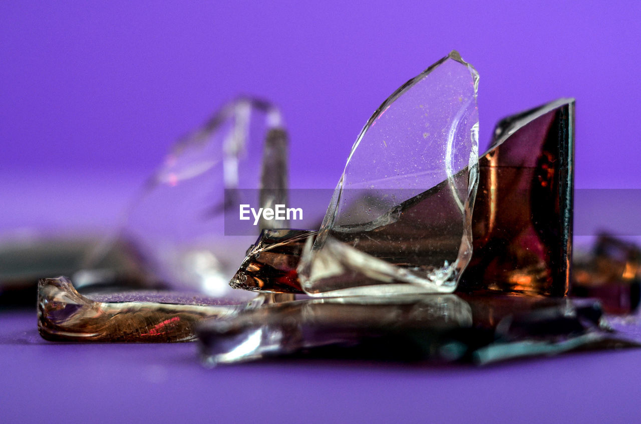 Close-up of broken glasses against blue background