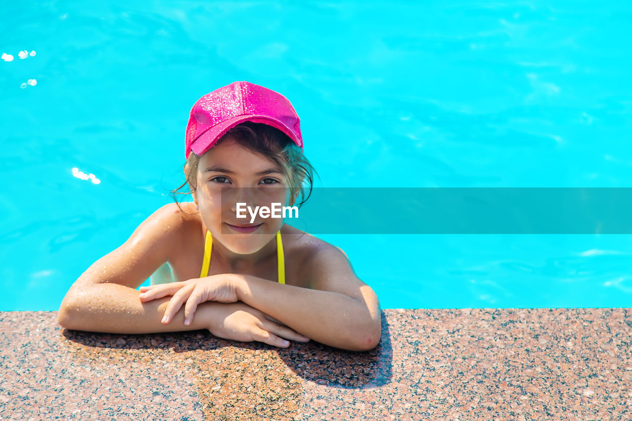 Portrait of girl wearing cap in swimming pool