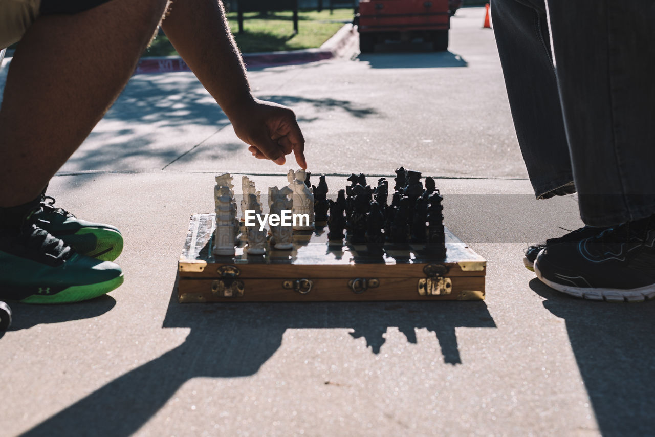 LOW SECTION OF MAN PLAYING ON CHESS BOARD