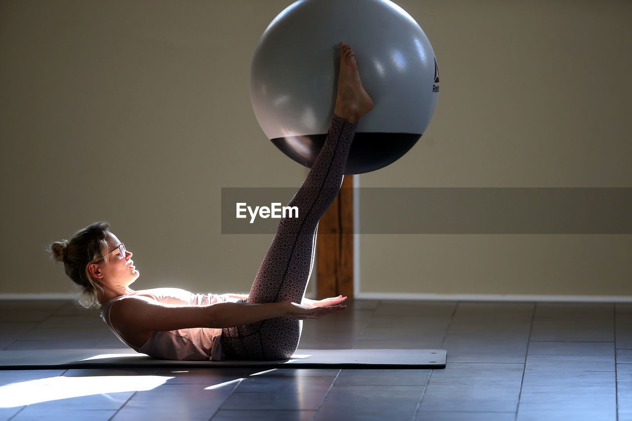 Woman exercising with medicine ball in yoga class