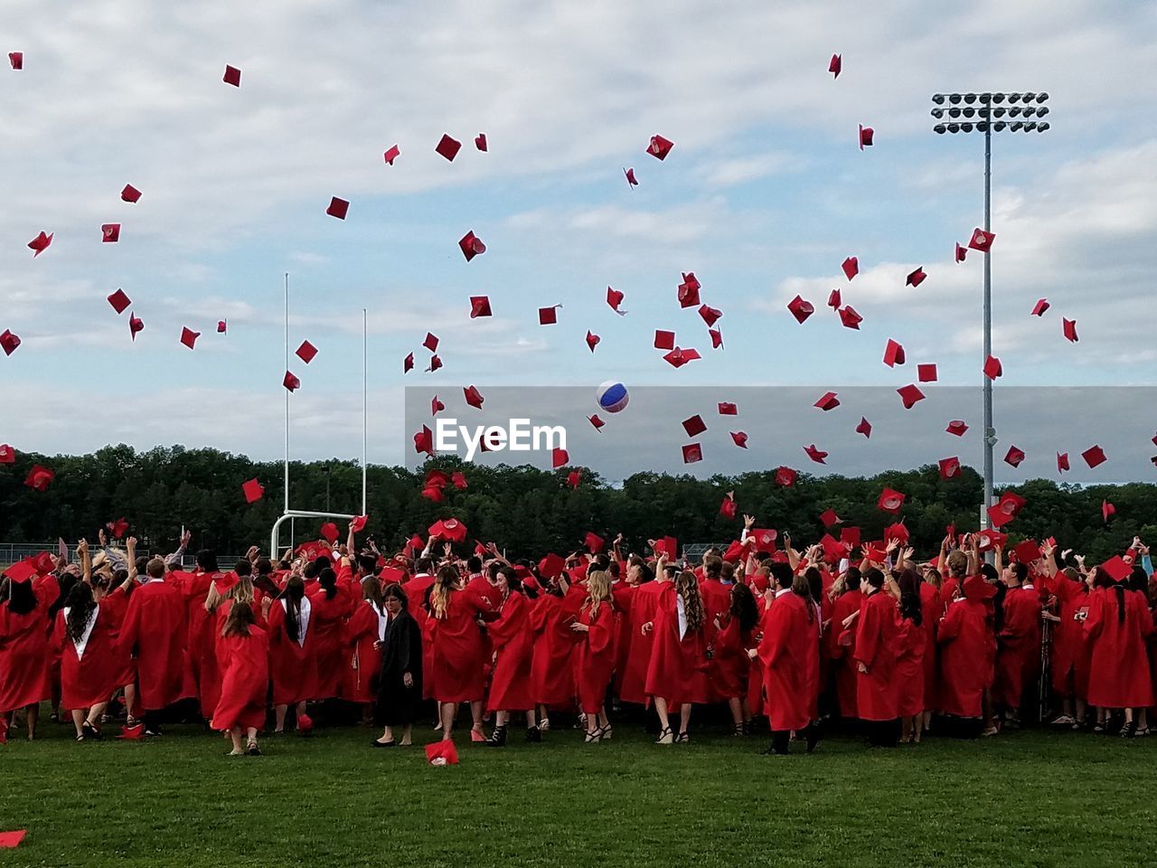 Graduation crowd throwing caps