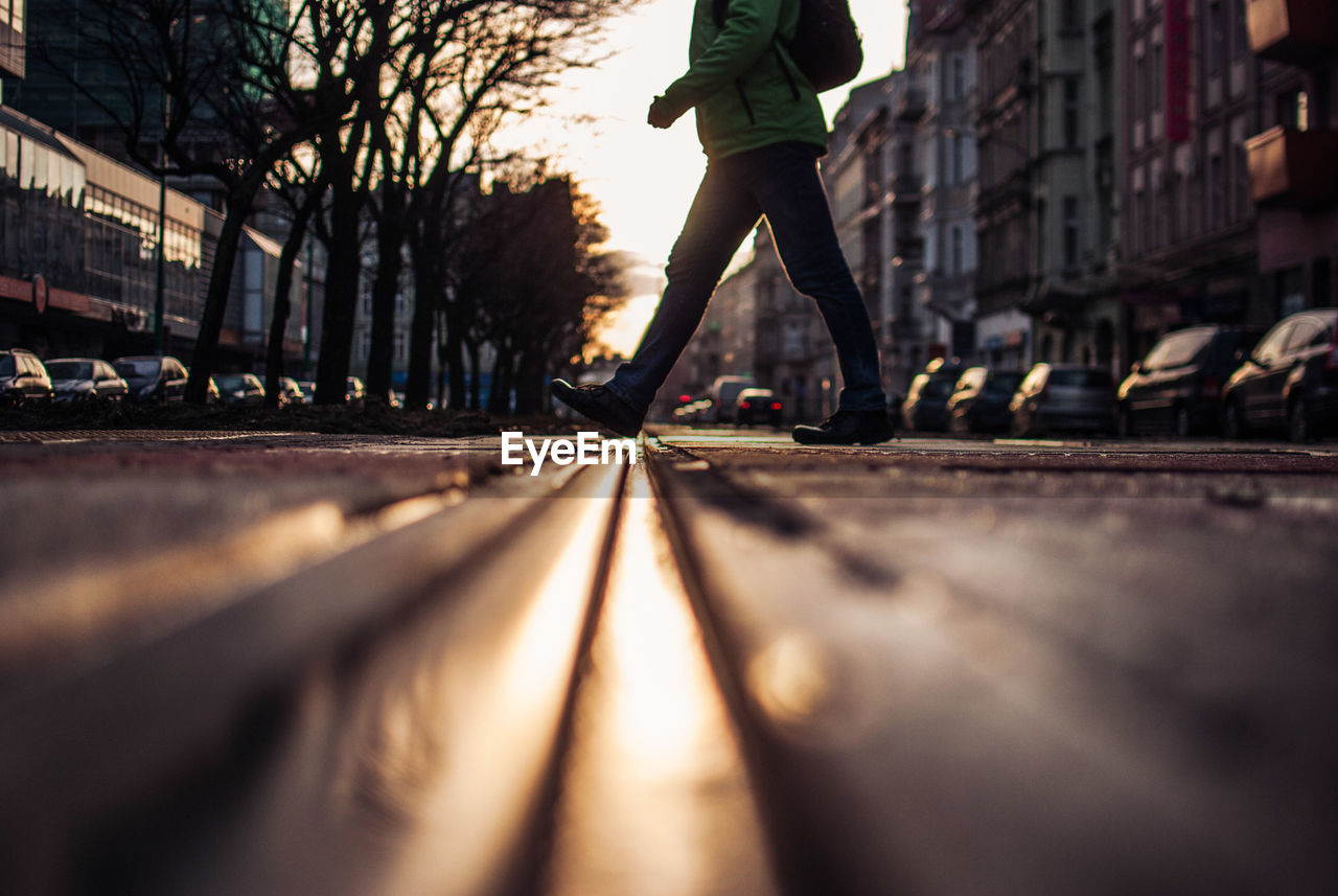 Low section of man walking on railroad track