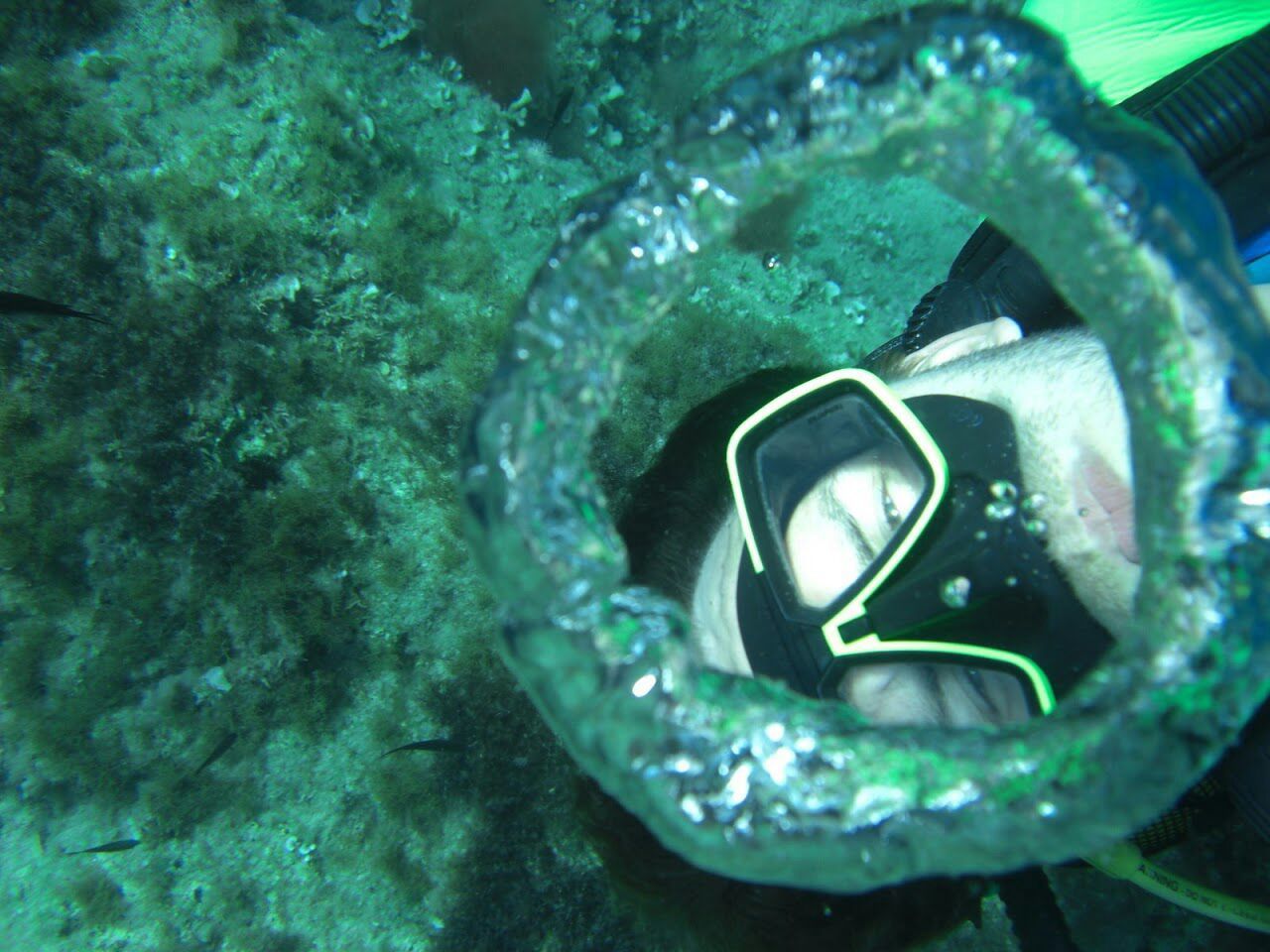Portrait of scuba diver seen through bubble in sea