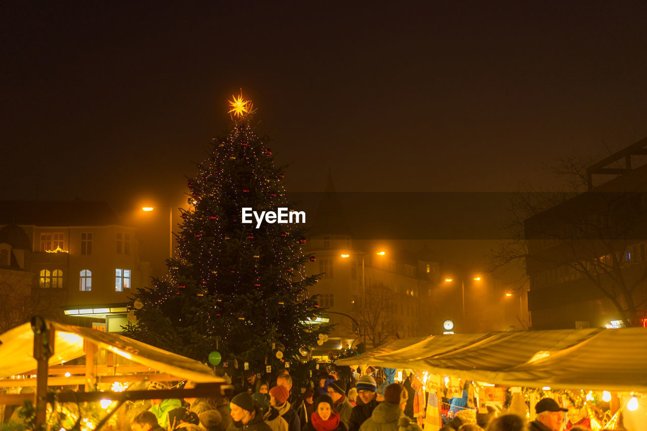 ILLUMINATED CHRISTMAS TREE AGAINST SKY AT NIGHT