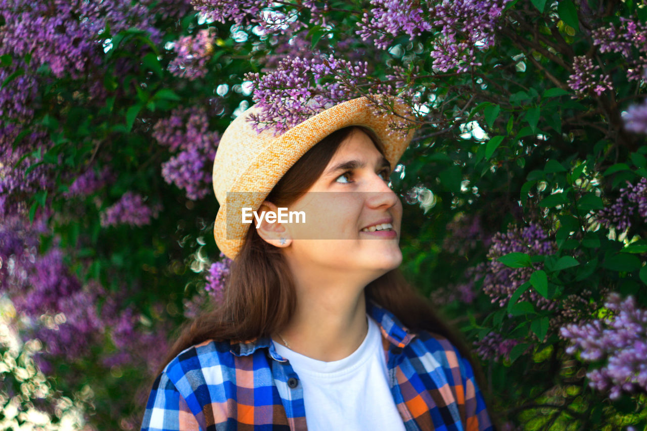 Spring girl. defocus beautiful young woman near blooming spring tree. bush lilac flowers. youth