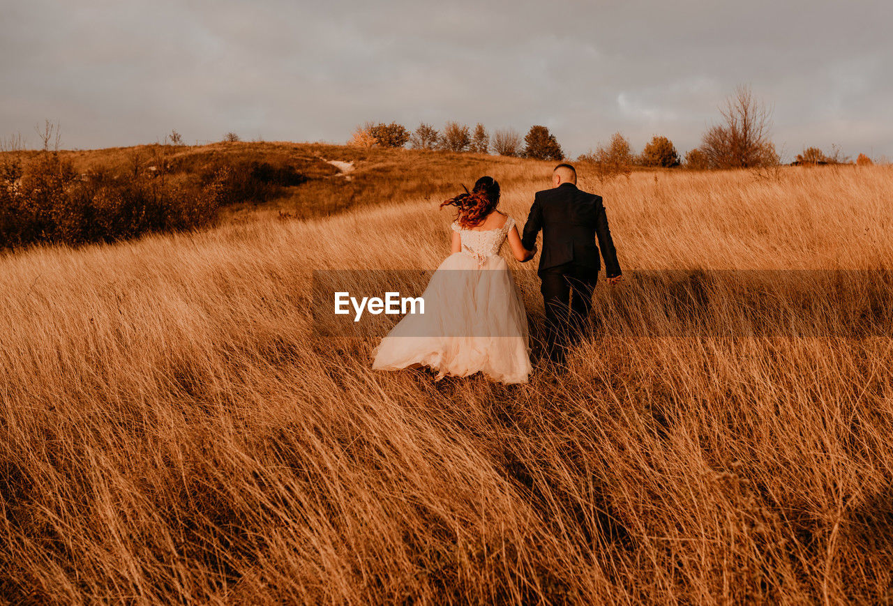 rear view of couple standing on field