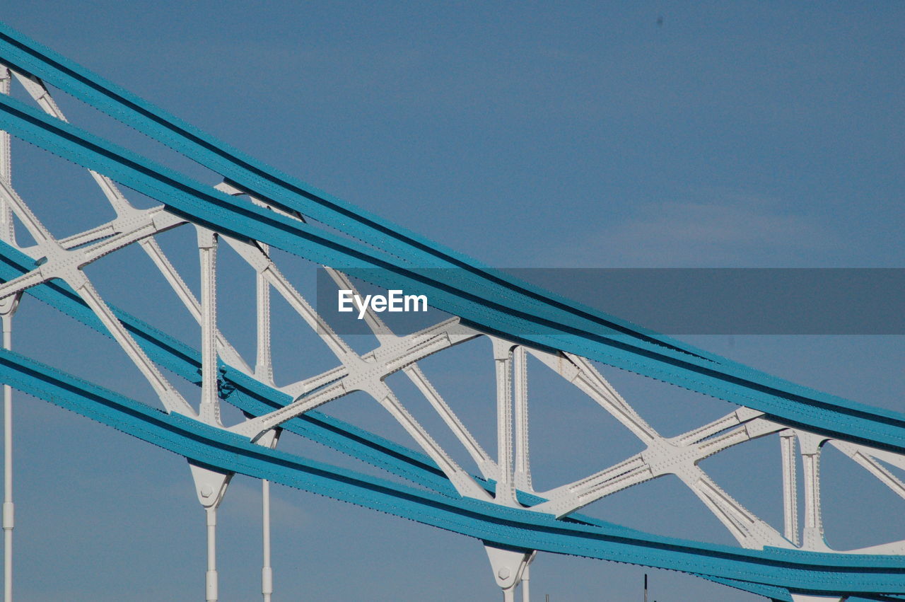 Low angle view of suspension bridge against clear blue sky