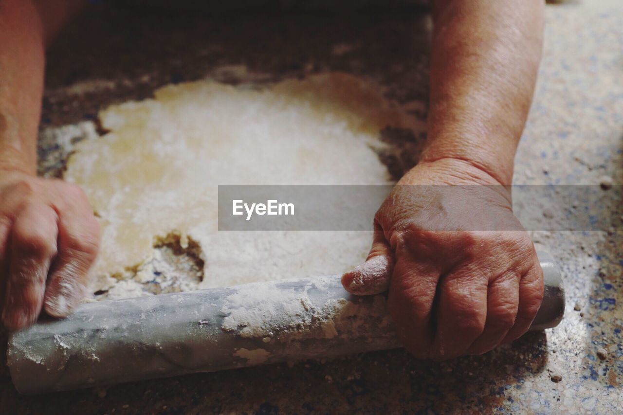 Cropped image of person holding rolling pin