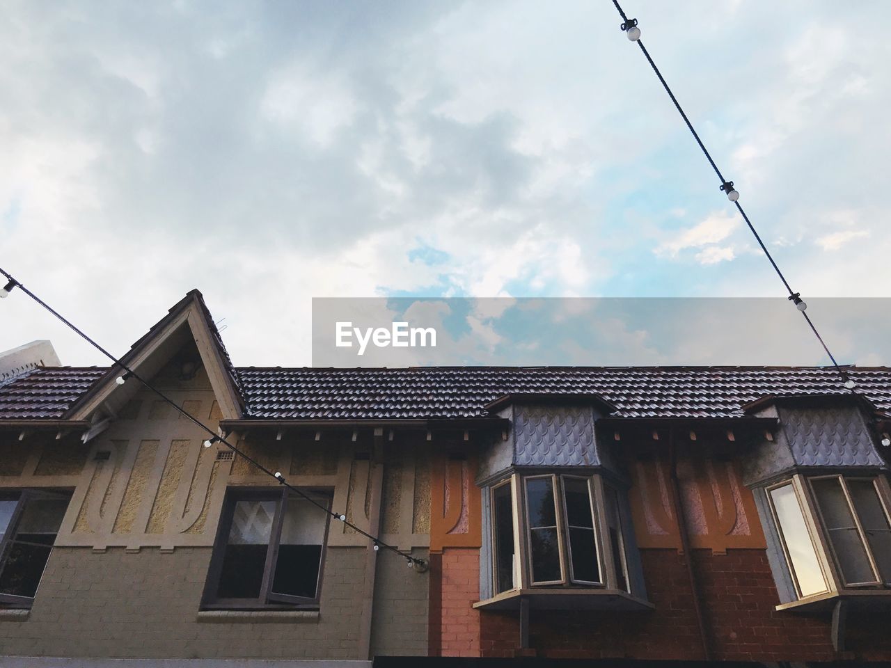 LOW ANGLE VIEW OF HOUSE AGAINST CLOUDY SKY