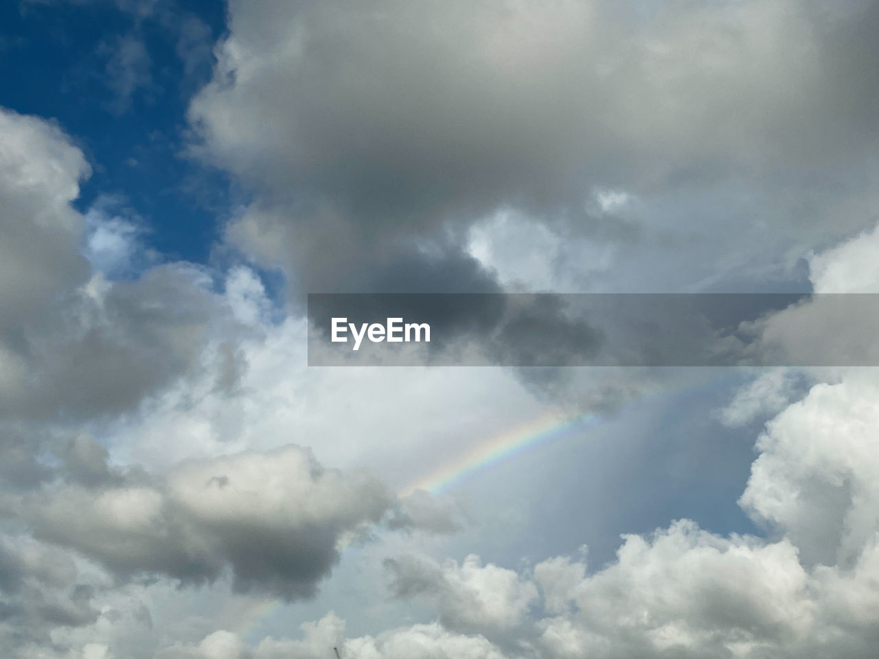 Low angle view of clouds in sky with a rainbow