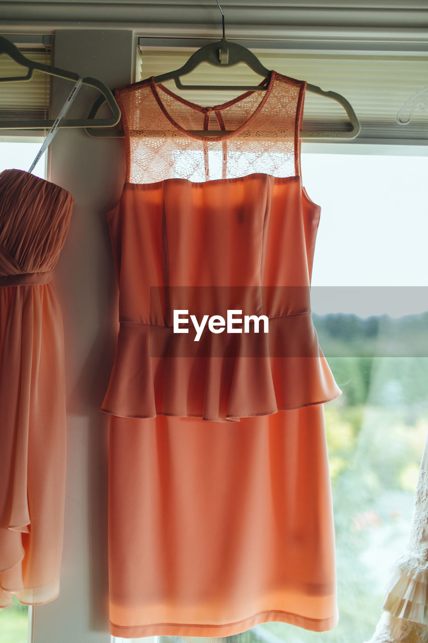 Dress hanging on window at home