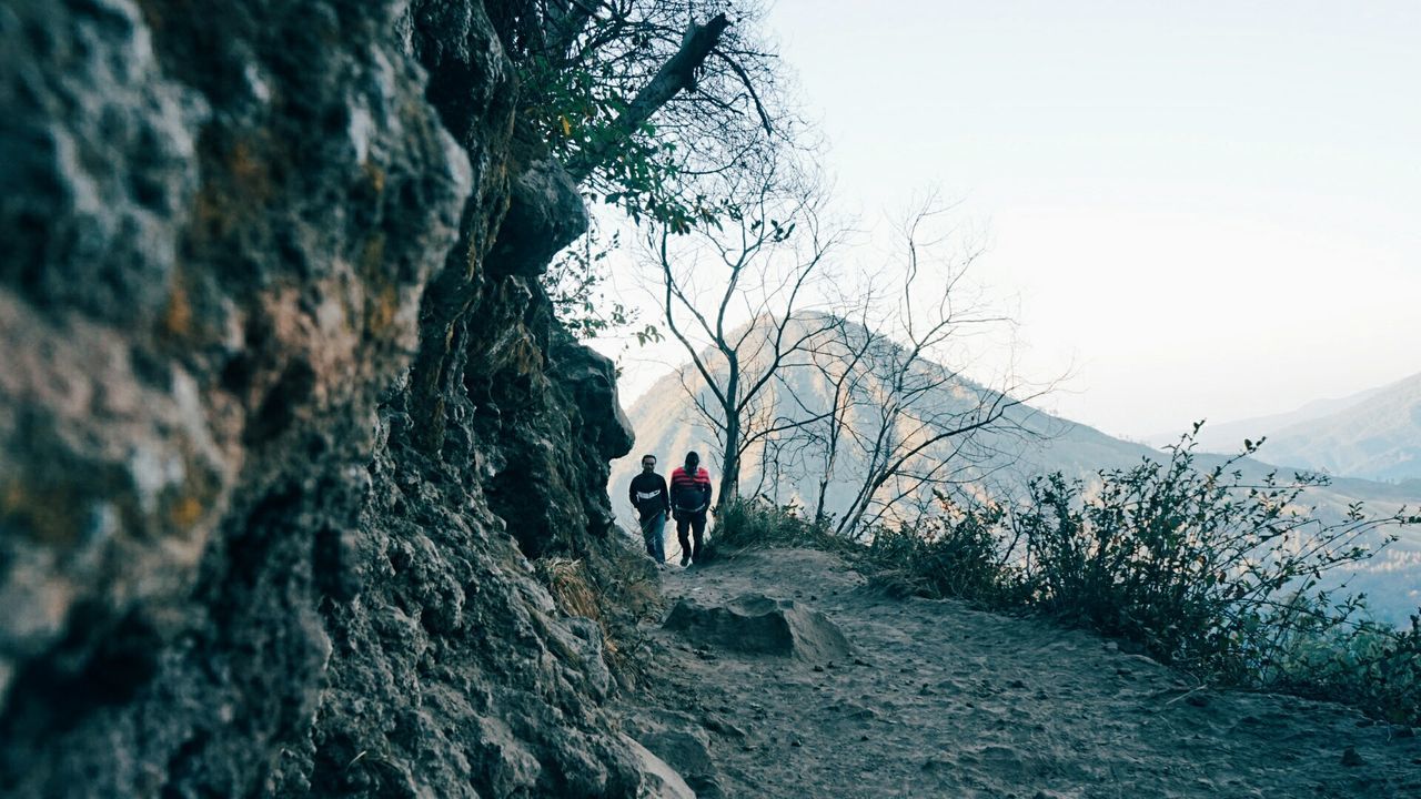 WOMAN WALKING ON ROCK FORMATION