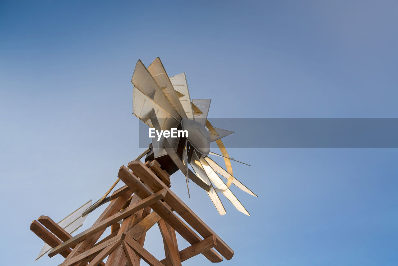 Low angle view of modern windmill against clear blue sky