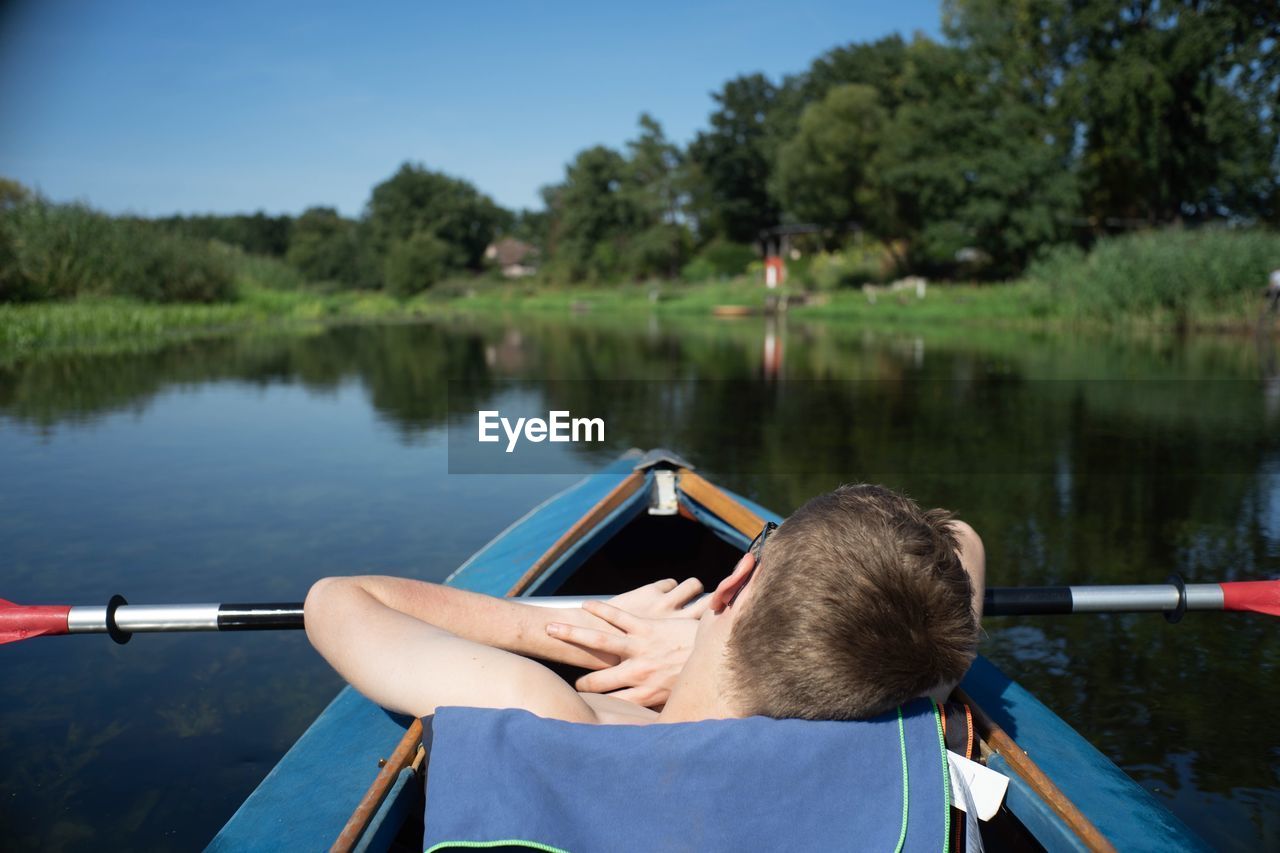 Rear view of men in boat on lake