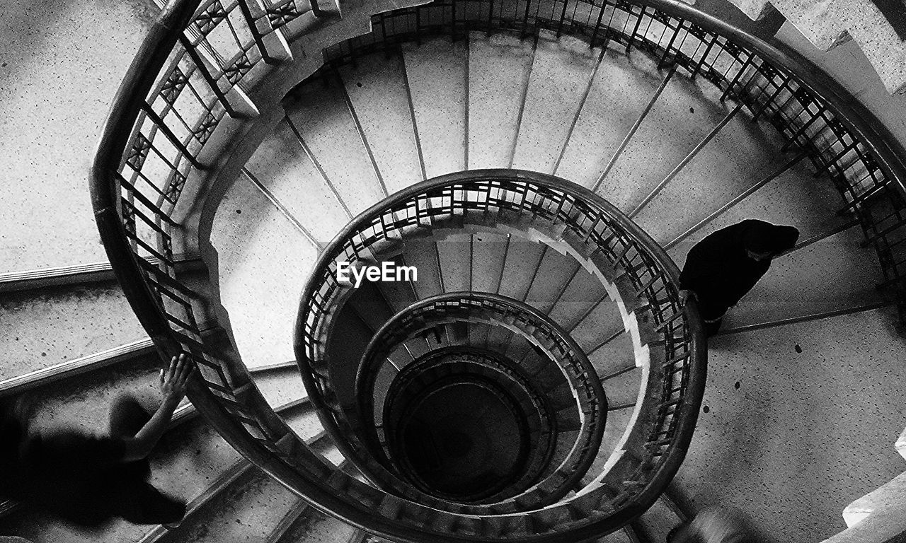 High angle view of people walking on spiral staircase in building