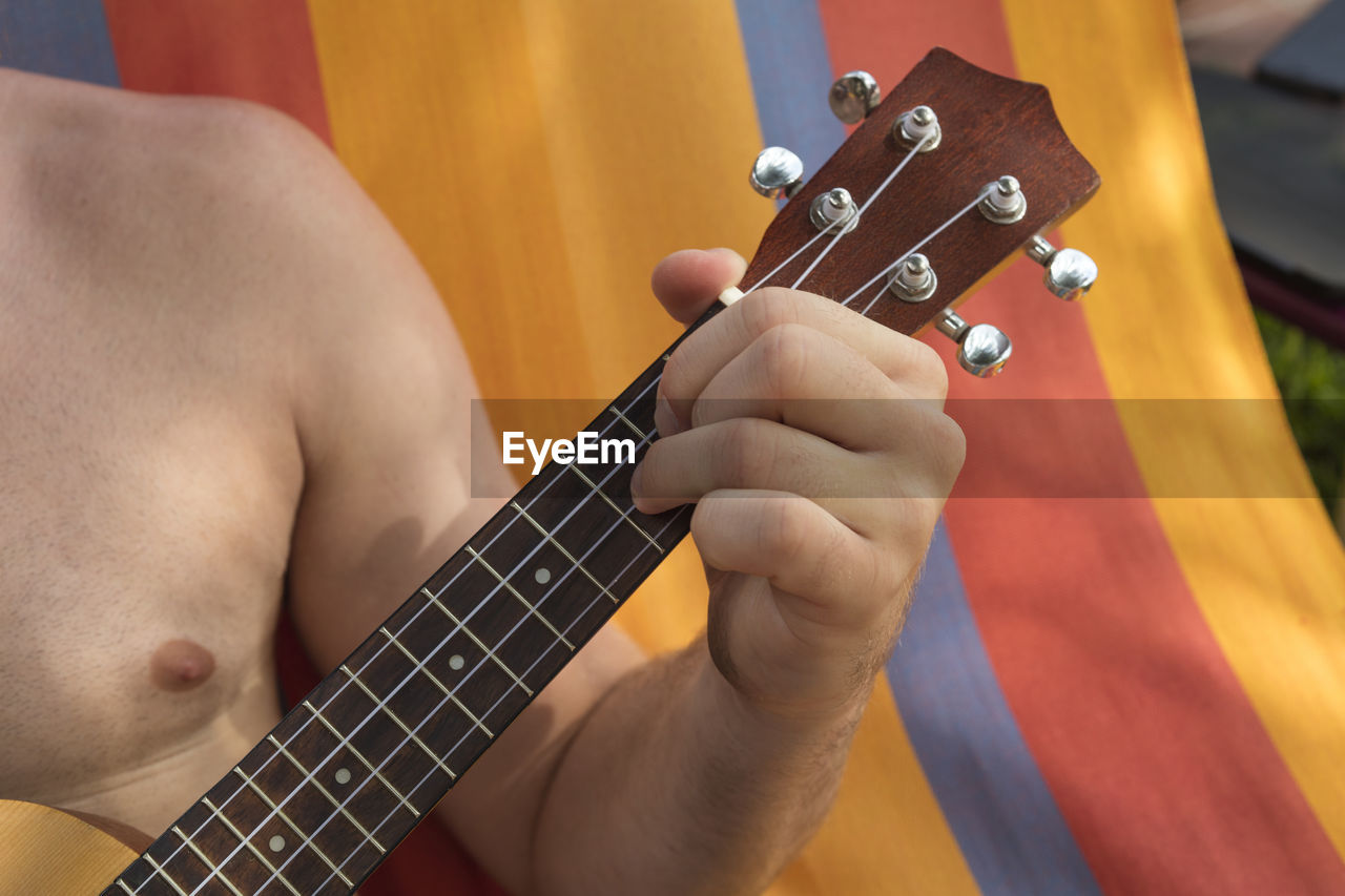 Cropped image of man playing guitar