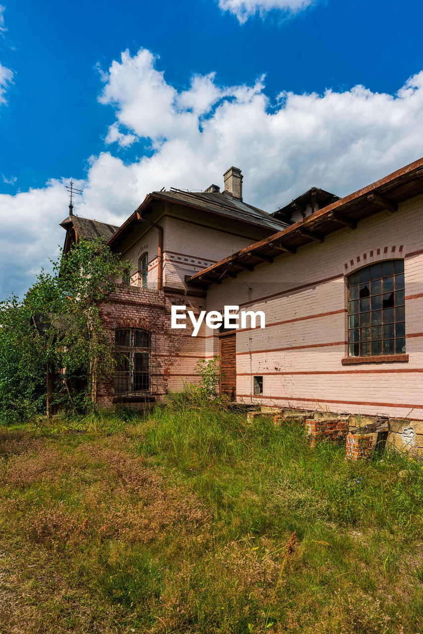 OLD HOUSE ON FIELD AGAINST SKY