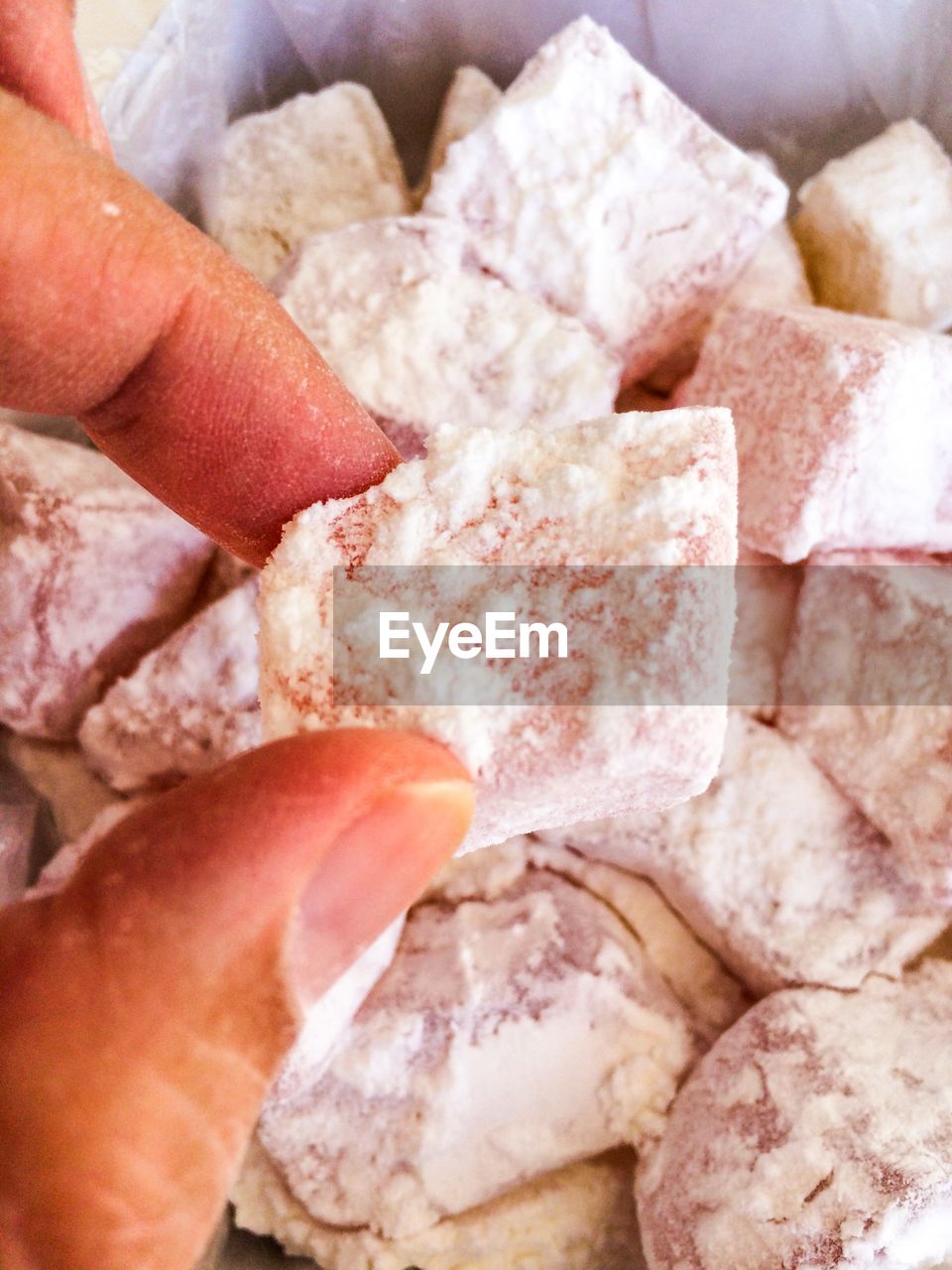 CLOSE-UP OF HAND HOLDING BREAD