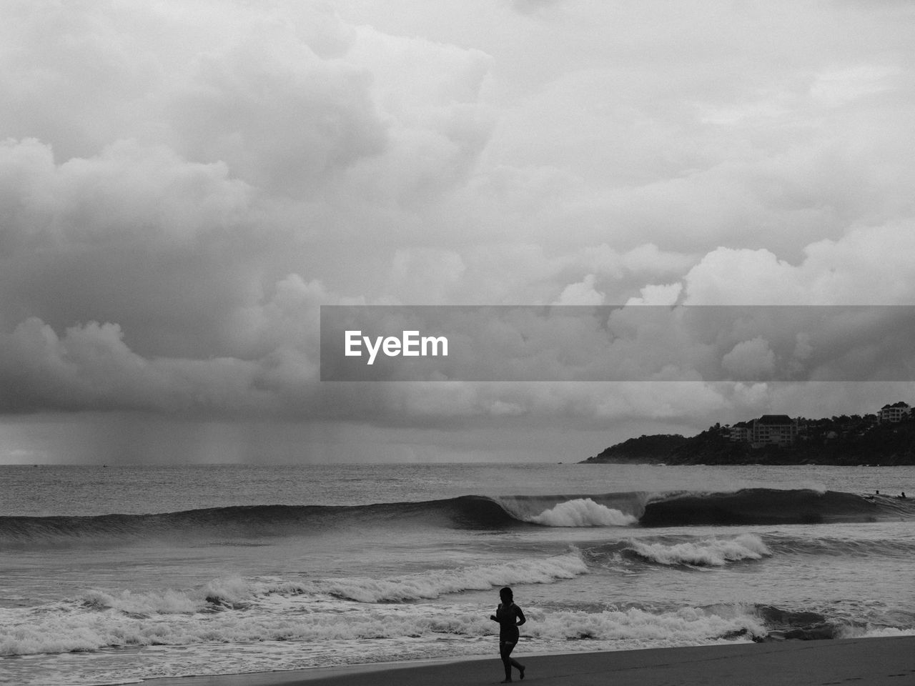 Woman on shore at beach against sky