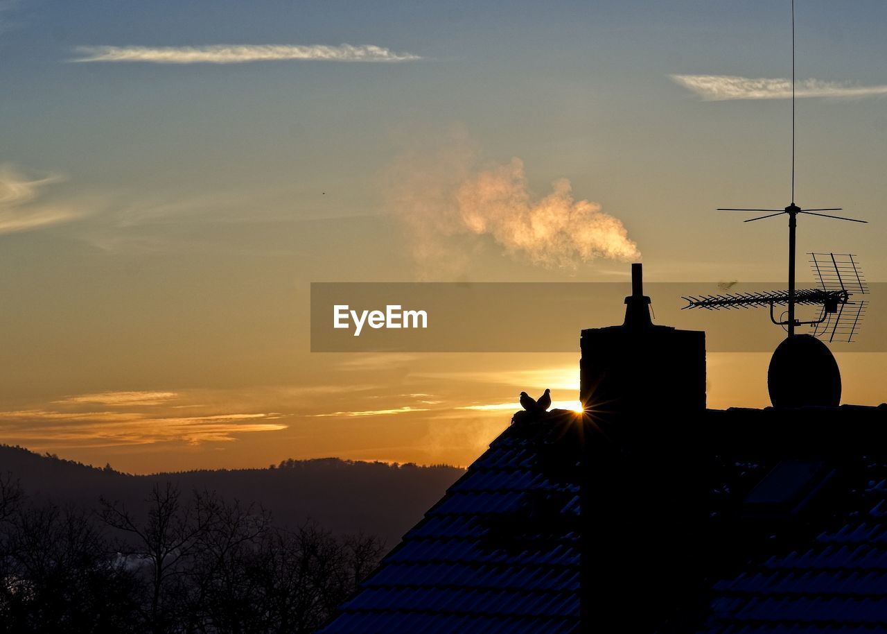 SILHOUETTE OF BUILDING AGAINST CLOUDY SKY