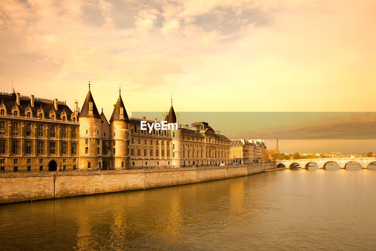 The conciergerie at justice palace and pont neuf bridge over the seine river, paris, france