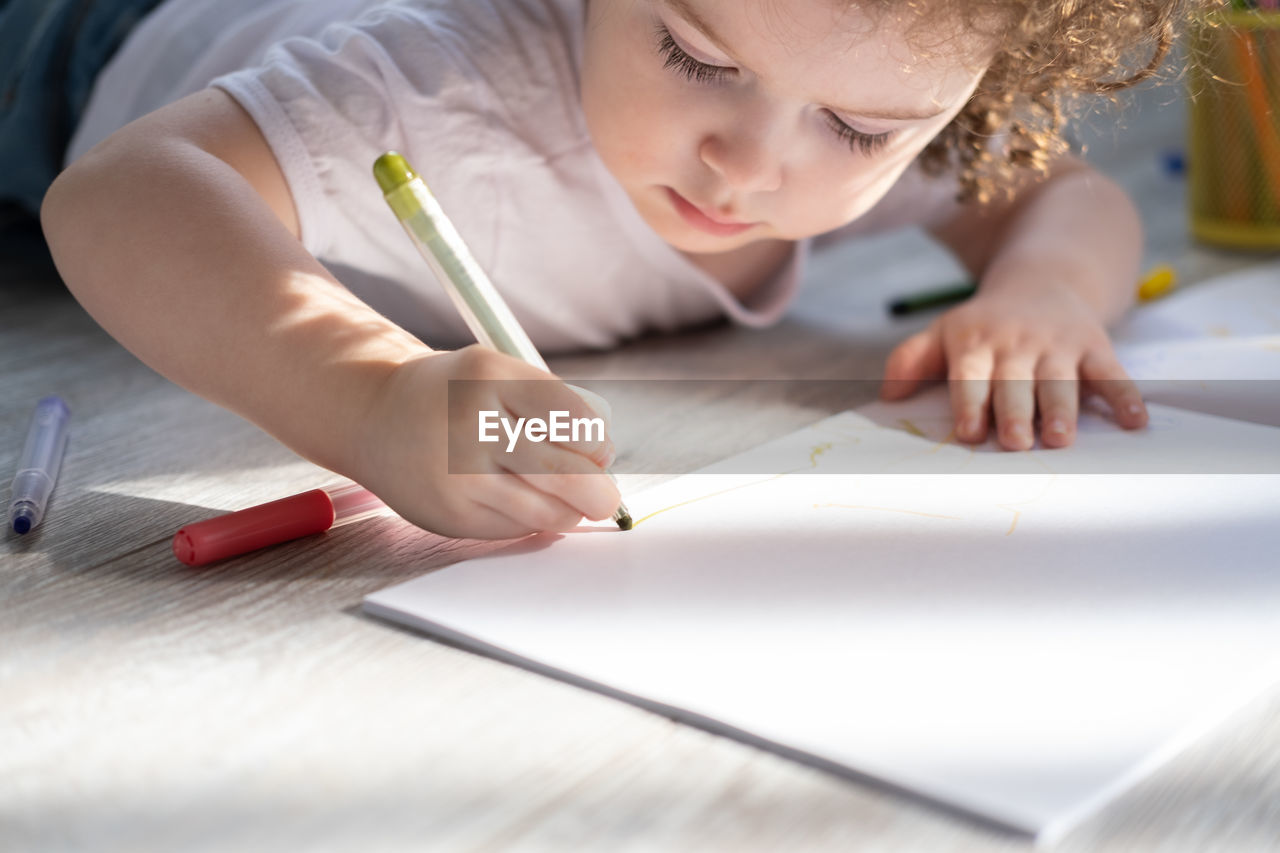 Cute girl drawing on book