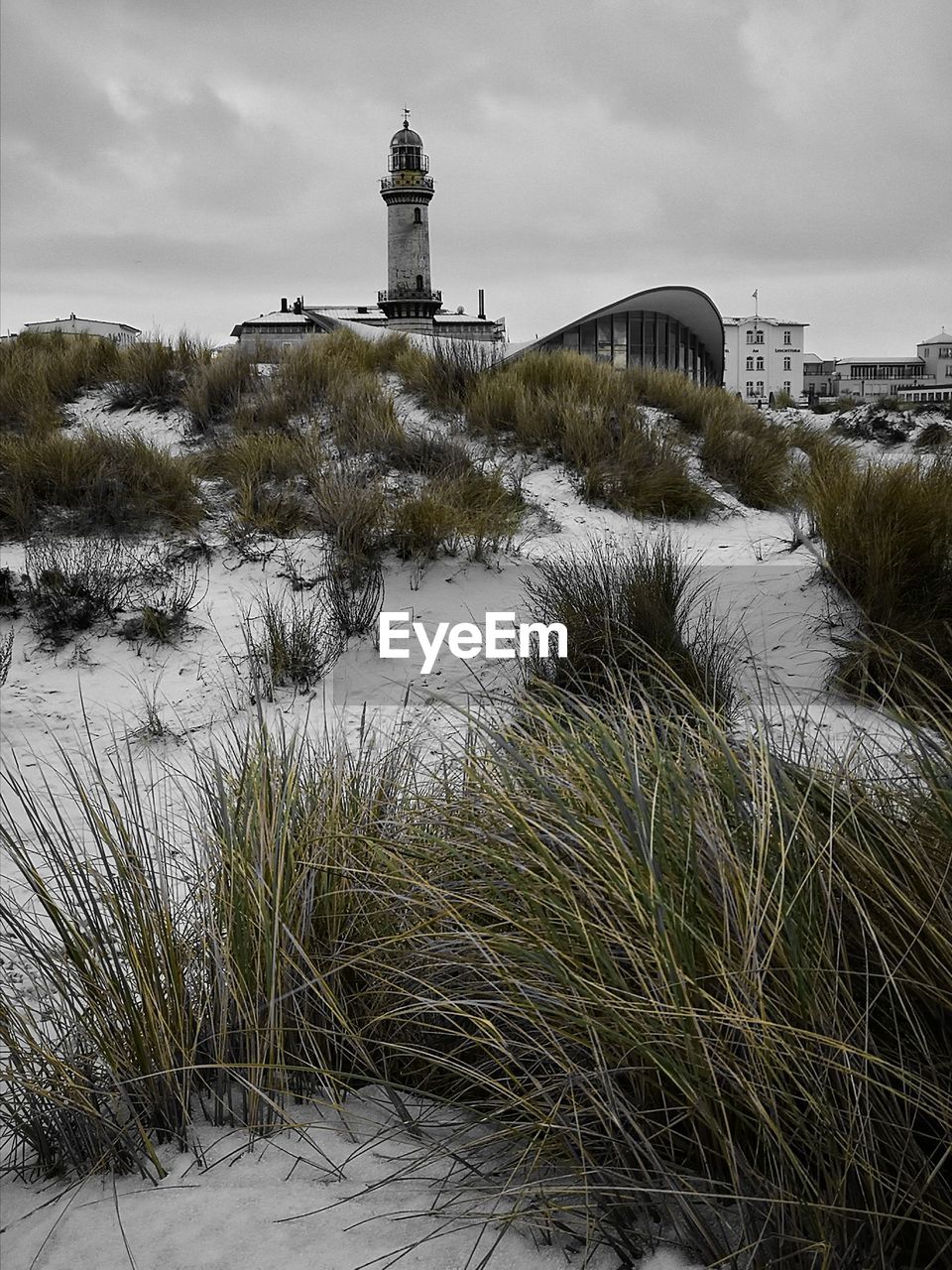 VIEW OF LIGHTHOUSE BY BUILDING AGAINST SKY