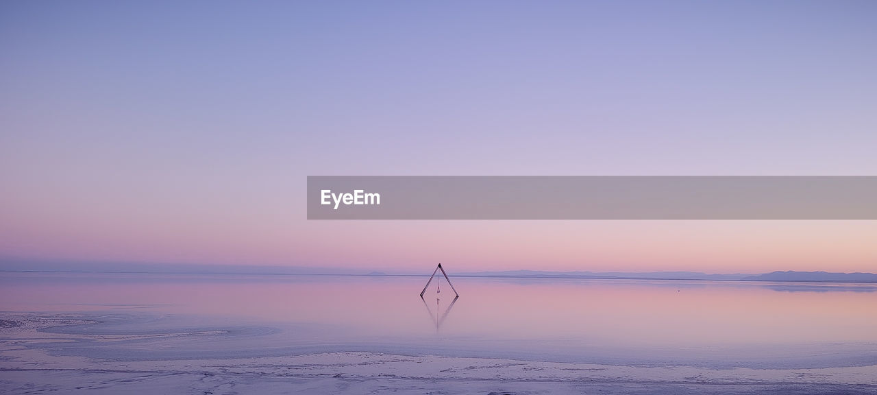 scenic view of sea against clear sky at sunset