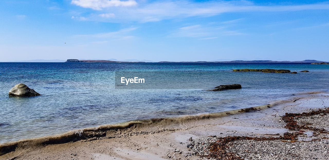 SCENIC VIEW OF ROCKS ON BEACH AGAINST SKY