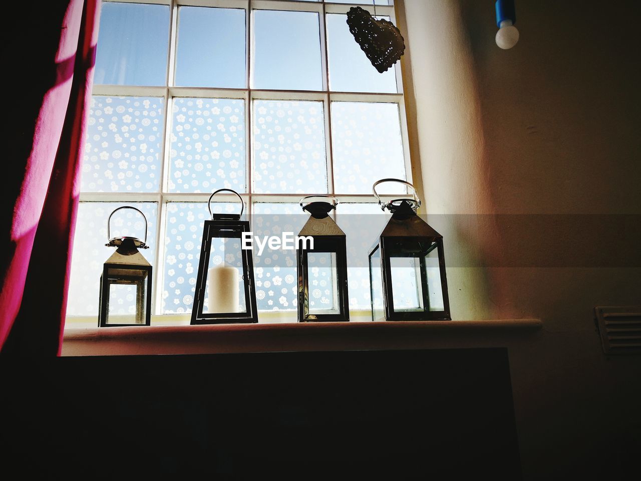 Close-up of lanterns on window at home