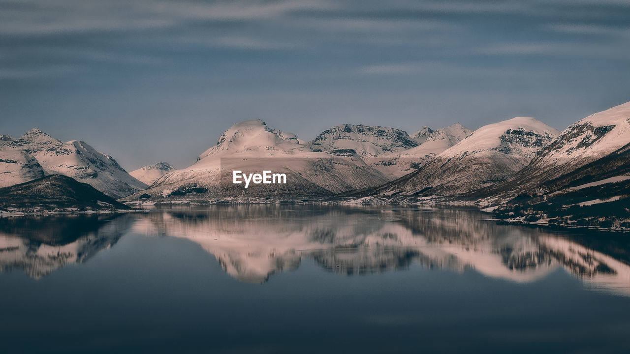 Scenic view of lake and snowcapped mountains against sky