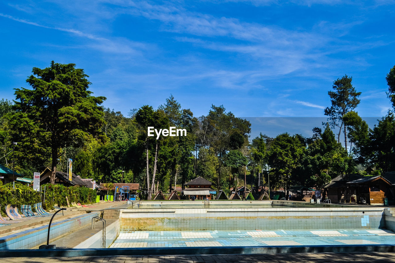 VIEW OF SWIMMING POOL AGAINST TREES