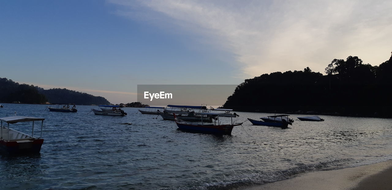 BOATS IN SEA AGAINST SKY DURING SUNSET