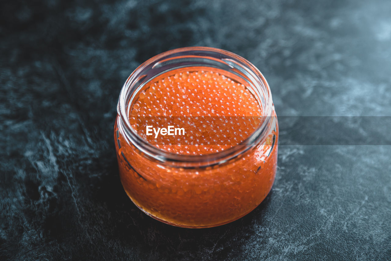 Red salted salmon caviar in a glass jar, fish caviar delicacy