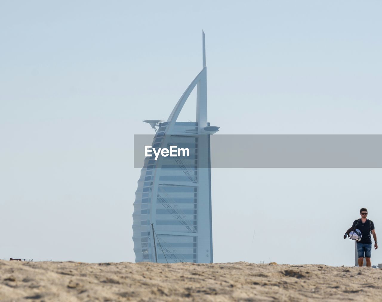 LOW ANGLE VIEW OF MAN STANDING AGAINST CLEAR SKY