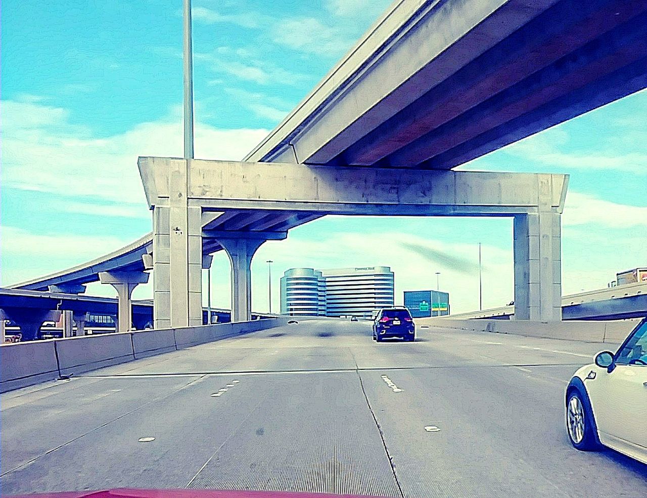 CARS ON ROAD AGAINST SKY IN CITY