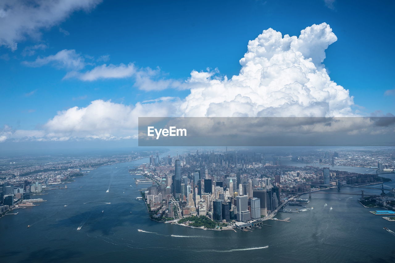 Aerial view of cityscape and river against sky