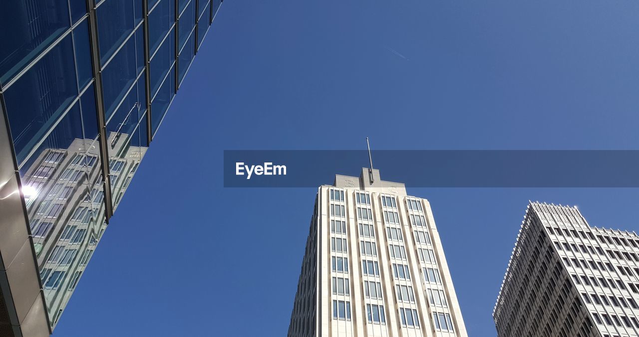 architecture, built structure, building exterior, skyscraper, office building exterior, building, city, sky, office, tower block, metropolitan area, blue, tower, low angle view, business, clear sky, nature, no people, landmark, metropolis, glass, downtown district, finance, downtown, residential district, facade, day, outdoors, skyline, cityscape, travel, corporate business, travel destinations, urban area, urban skyline, window, city life, sunlight, construction industry