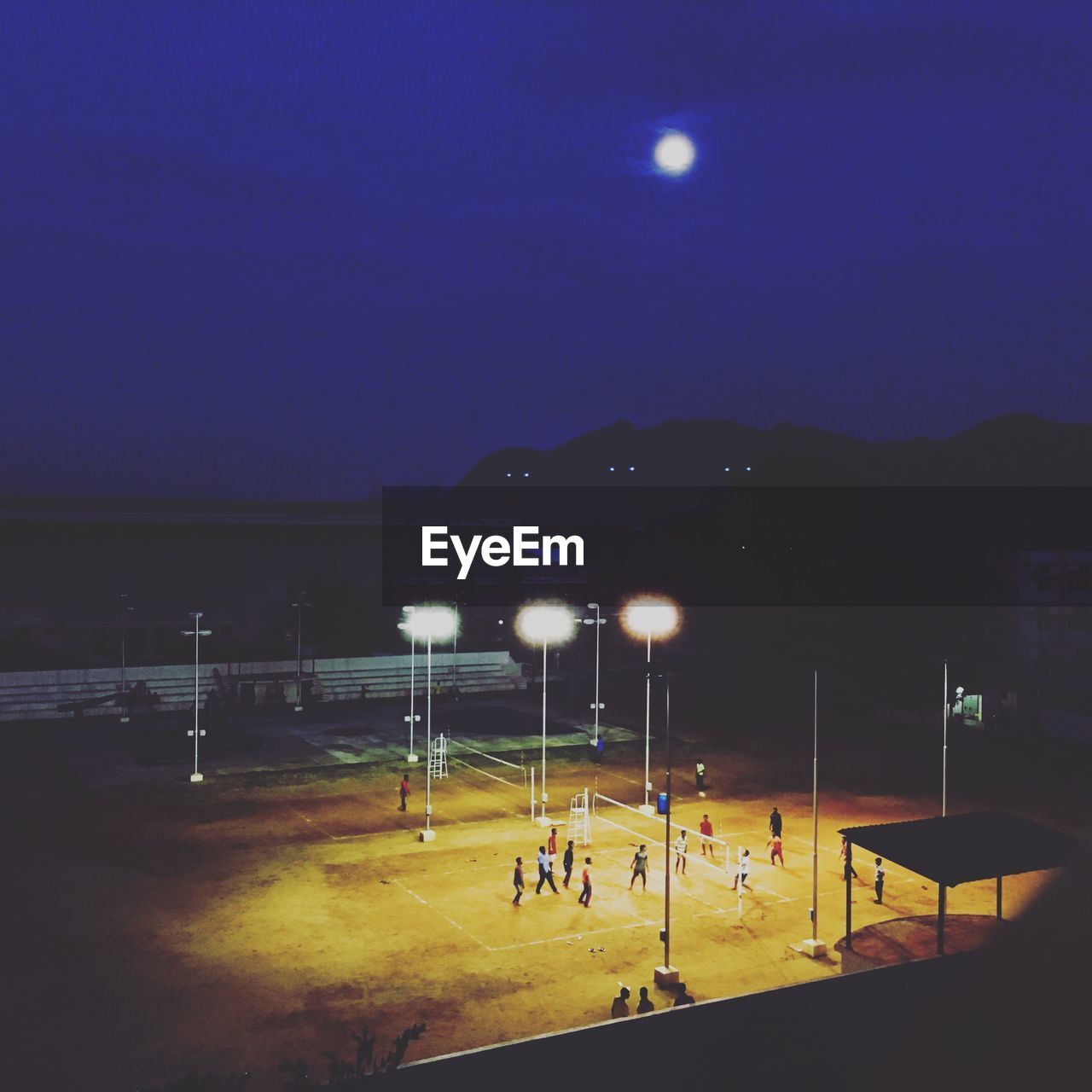 Distant view of people playing at playground during night