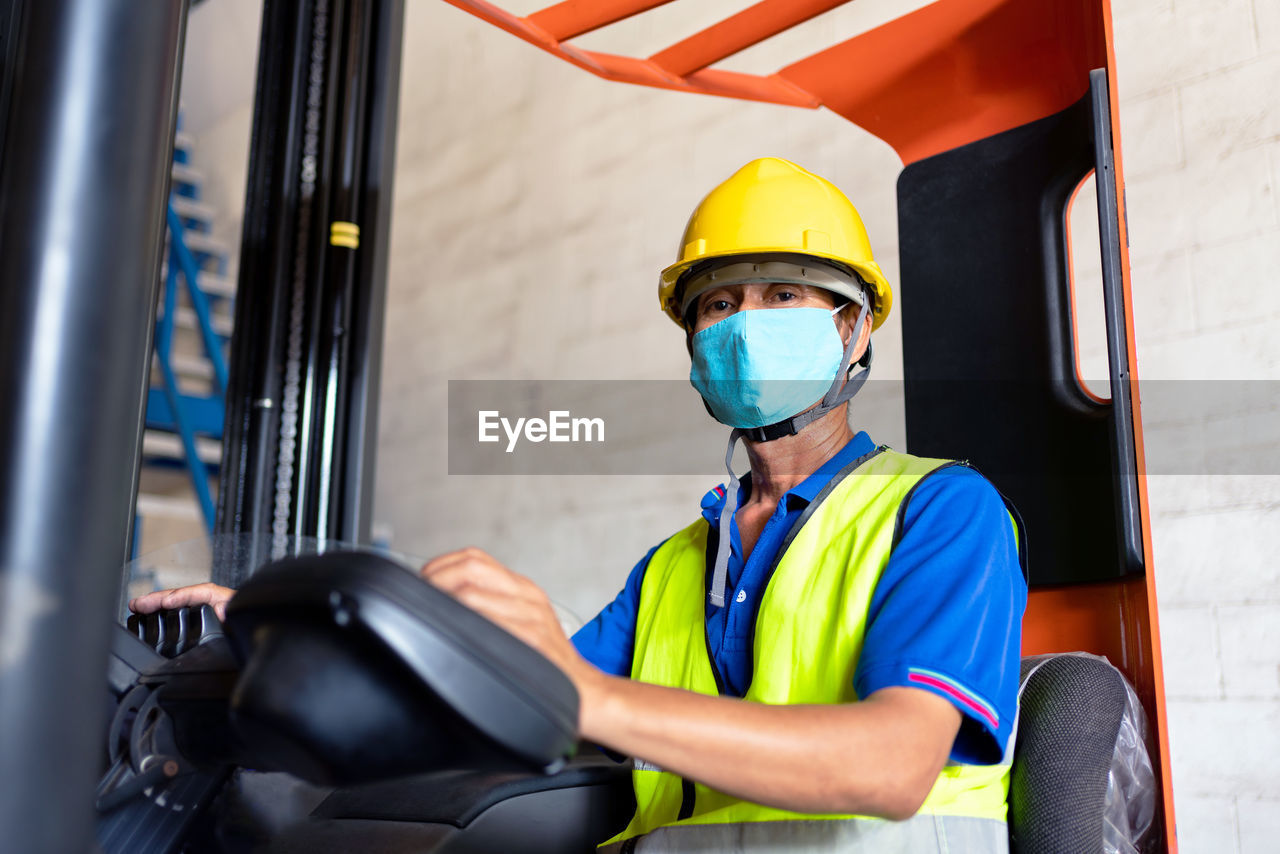 Portrait of worker wearing hardhat and mask