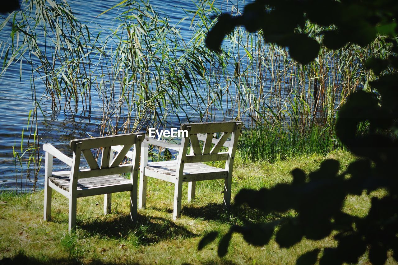 Empty chairs against rippled water