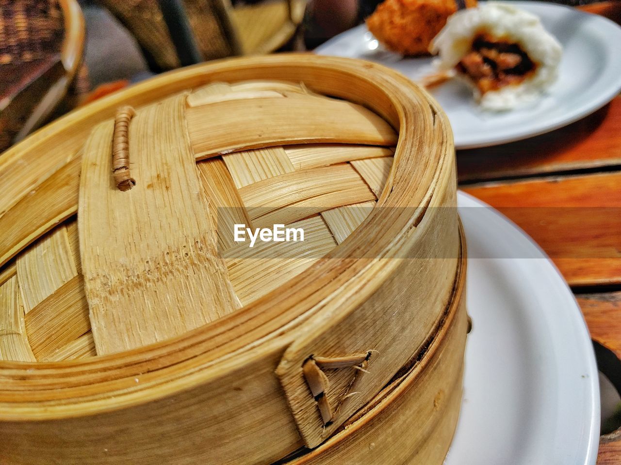 Close-up of bamboo steamer by food on table
