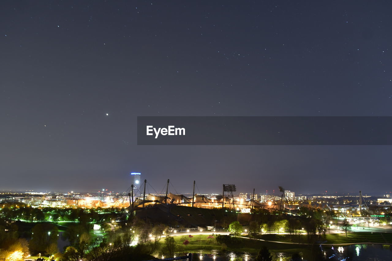 HIGH ANGLE VIEW OF ILLUMINATED BUILDINGS AT NIGHT