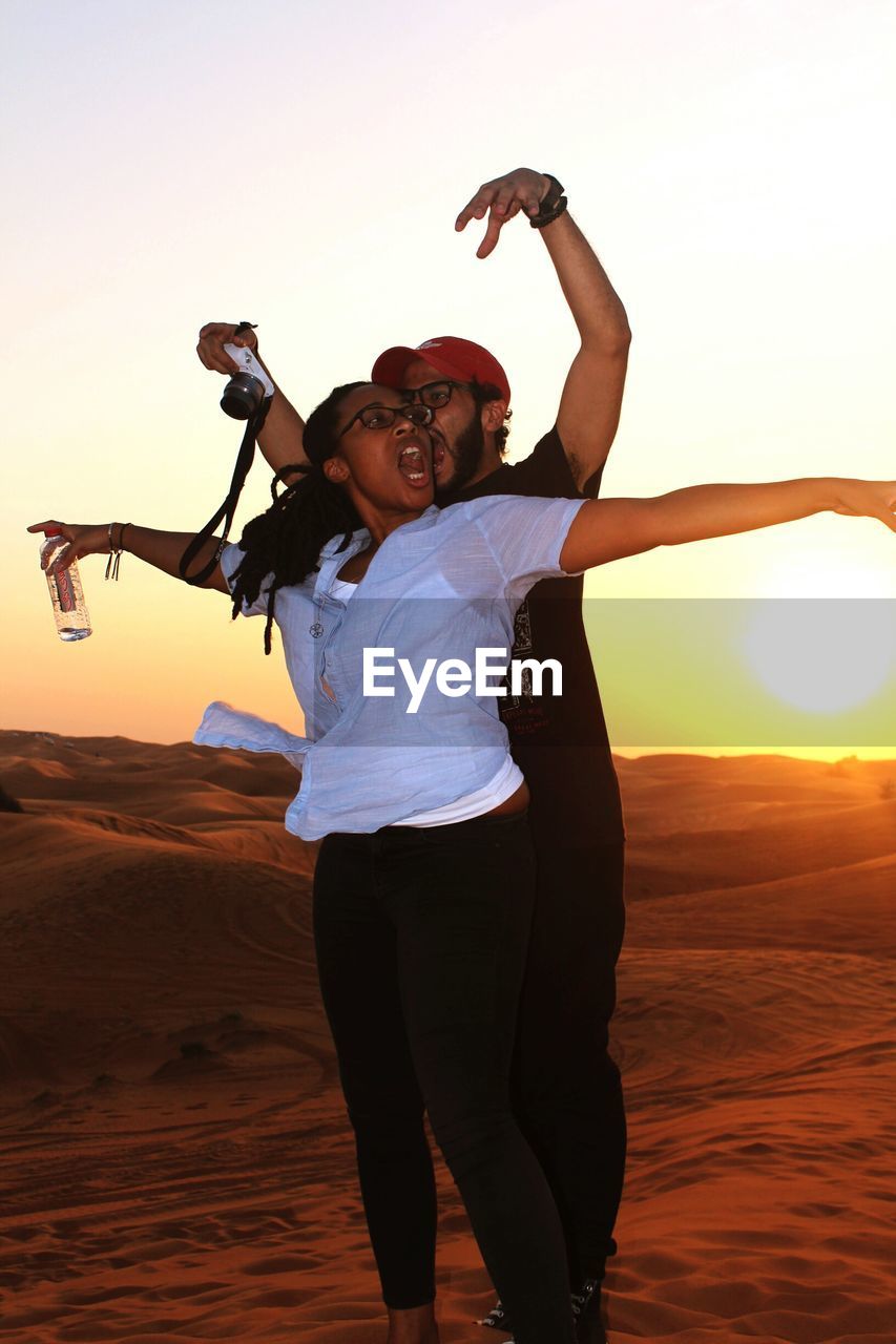 Couple enjoying in desert during sunset
